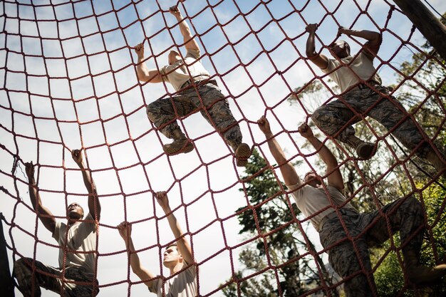 Soldati militari arrampicata su corda durante il percorso ad ostacoli