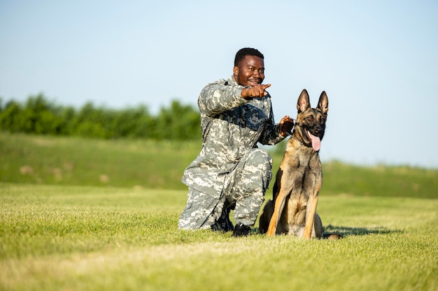 Soldato che dà un comando al suo cane militare al campo di addestramento