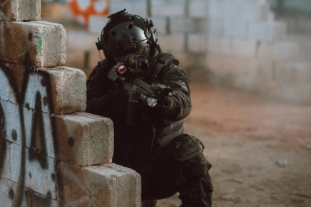 Soldato che tiene il fucile nell'area del campo di battaglia pronto a combattere Concetto di stile guerriero combattimento pistola BB.