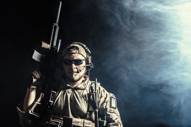 Soldato delle forze speciali con il fucile su sfondo scuro
