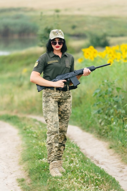 Soldato donna in uniforme militare Una ragazza in uniforme militare con un'arma