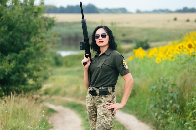 Soldato donna in uniforme militare Una ragazza in uniforme militare con un'arma