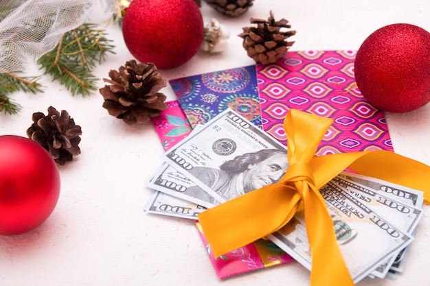 Soldi come regalo per il nuovo anno, natale, dollari legati con l'estate dorata, fiocco, buste per appunti