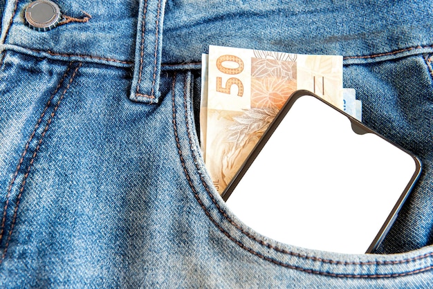 Soldi e cellulare con schermo vuoto nella tasca dei jeans