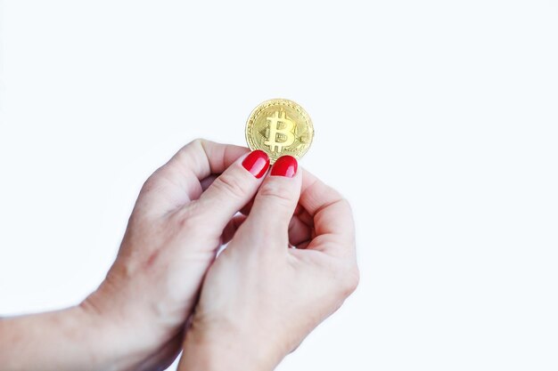 Soldi virtuali bitcoin oro donne mano con unghie rosse dita isolate su sfondo bianco