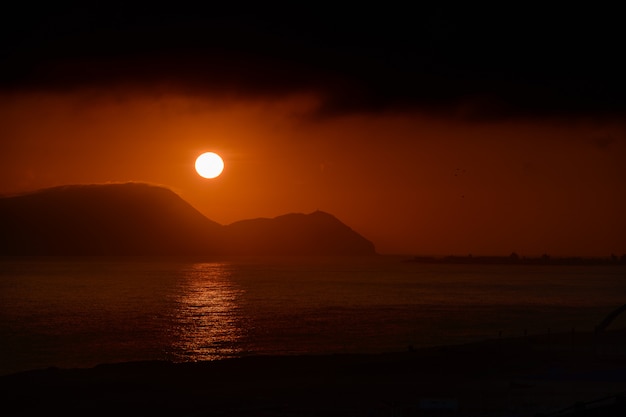 Sole ardente al tramonto sopra l'oceano Pacifico nel Perù