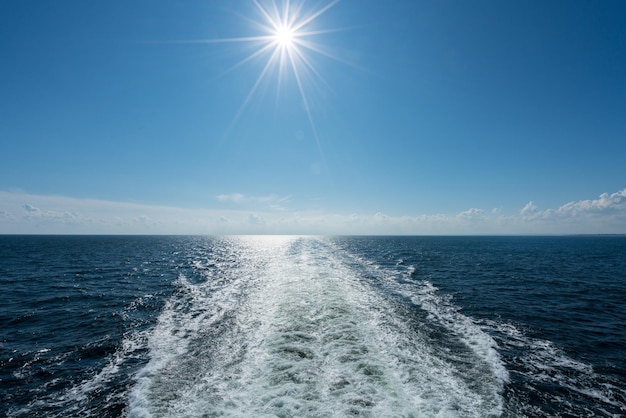 Sole che splende sulla scia della nave da crociera in mare