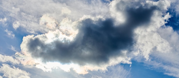 Sole dietro nubi cumuliformi blu bellissimo paesaggio nuvoloso con luce solare Bellissimo sole da dietro nubi cumuliformi sul cielo blu del giorno Soffice tempo nuvoloso sullo sfondo della natura