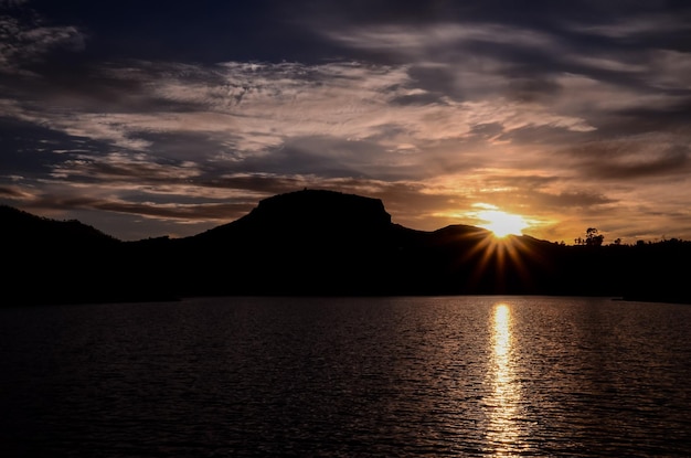 Sole dietro una silhouette di montagna a Gran Canaria Spagna