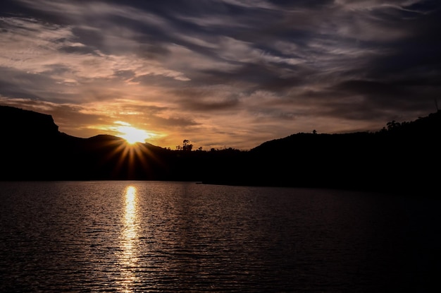 Sole dietro una silhouette di montagna