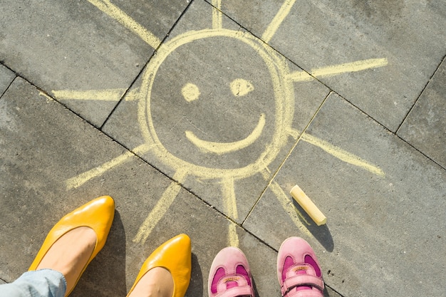 Sole giallo e piedi di donna e bambino