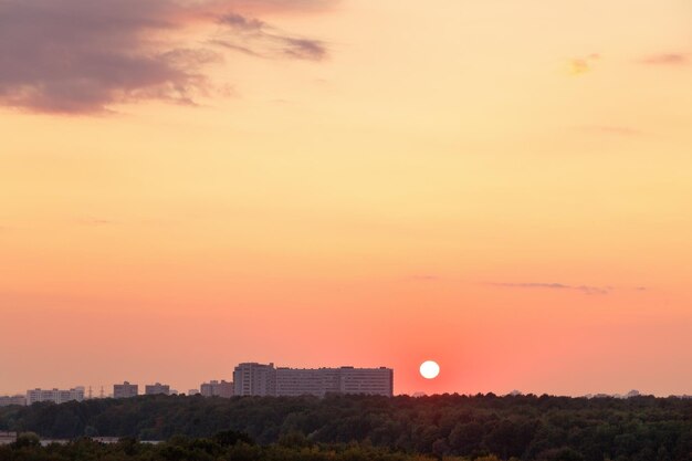 Sole sopra l'orizzonte durante l'alba rossa sulla città