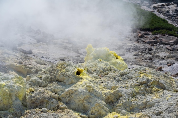 Solfatara fumante tra depositi di zolfo su un campo di fumarole alle pendici di un vulcano