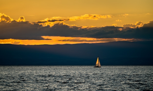 Solitario yacht a vela sul Lago di Ginevra al tramonto in Svizzera