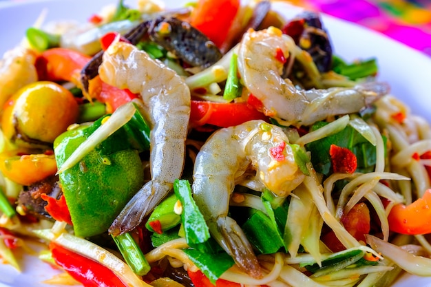 Som Tam Seafood (insalata di papaya piccante) con granchio salato, sul tavolo di legno (cibo tailandese)