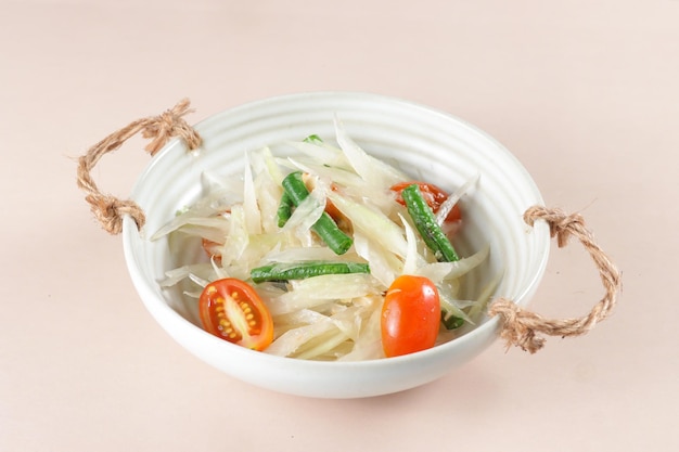 Som Tum è l'insalata di papaya verde tailandese, servita in una ciotola.