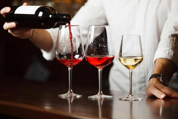 Sommelier che versa diversi tipi di vino pregiato