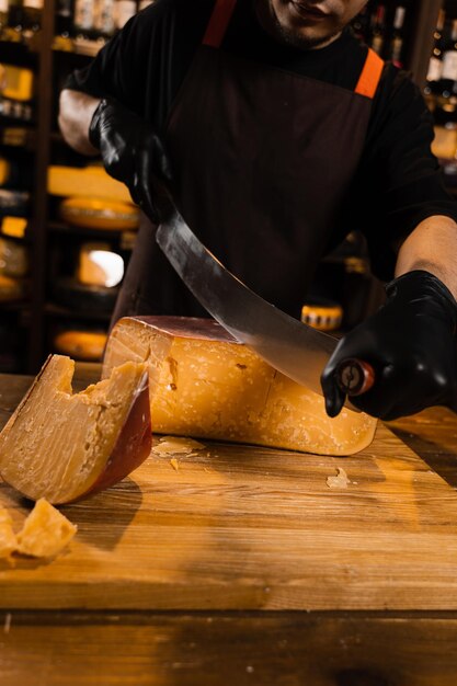 Sommelier di formaggio che taglia il formaggio gouda limitato con il coltello Spuntino gustoso pezzo di formaggio per antipasto