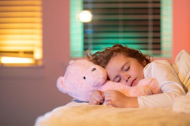 Sonno dolce bambino che dorme con un orsacchiotto giocattolo a letto bambino che dorme a letto sotto la coperta ragazzo sdraiato