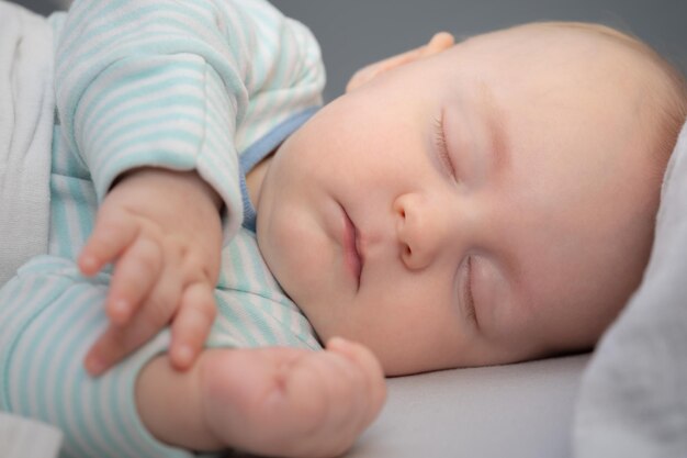Sonno spensierato piccolo bambino nel suo letto in camera bambino pacifico sdraiato sul letto con gli occhi chiusi