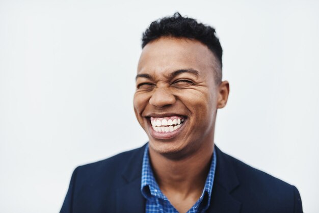 Sono l'uomo più felice del mondo intero Foto in studio di un giovane uomo d'affari sorridente e di buon umore su uno sfondo grigio