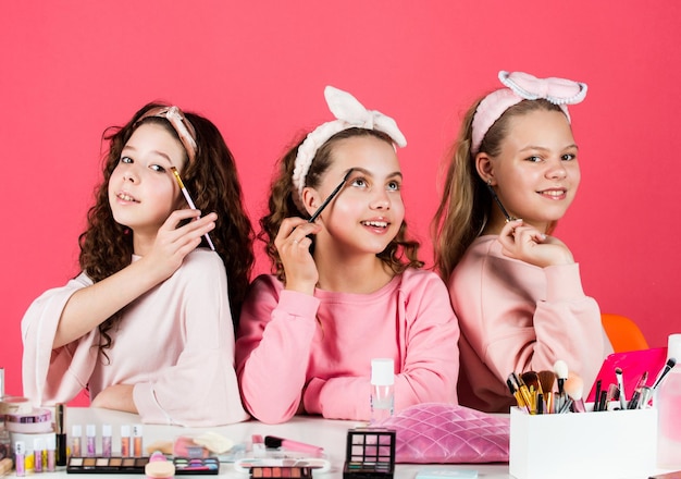 Sono una festa di amicizia davvero carina con cosmetici rilassati e divertirsi piccole ragazze nel salone di bellezza sorelline nel trucco del velo moda retrò per bambini gruppo di amici felici alla spa