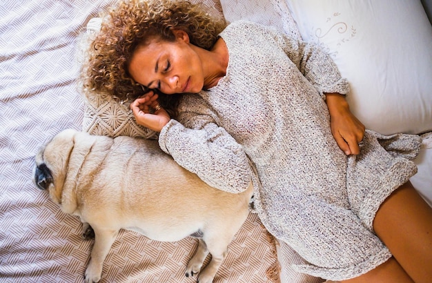 Sopra la vista della bella donna adulta e del cane addormentati insieme sul letto Persone di sesso femminile e animale amicizia e concetto di amore Cane e uomo che dormono insieme Migliore amico per sempre animale