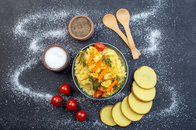 Sopra la vista di una deliziosa patata con verdure fresche spezie cucchiai di pomodori su sfondo bianco nero a colori misti con spazio libero