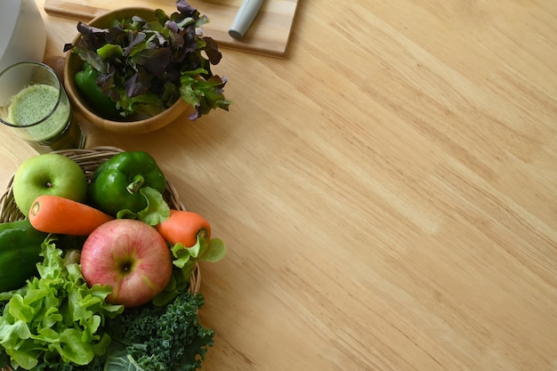 Sopra la vista verdure e frutta organiche in cesto di vimini sulla tavola di legno