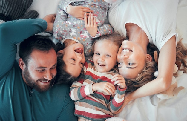 Sopra ritratto e famiglia felice a letto per amore supporto e rilassarsi insieme a casa mamma papà e genitori con i bambini o eccitato a casa cura e protezione o mattina per i bambini in appartamento