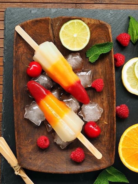 sorbetto gelato alla frutta multicolore fatto in casa con arancia limone ciliegia lampone e foglie di menta