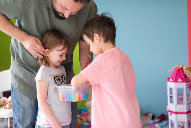 sorella e fratello si divertono e giocano a giochi di parrucchiere a casa con il padre