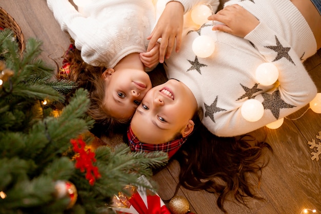 sorella giace accanto a un albero di Natale