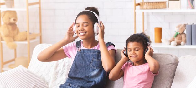 Sorelle afroamericane felici che si godono la musica preferita