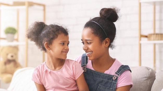 Sorelle afroamericane felici che si sorridono a vicenda