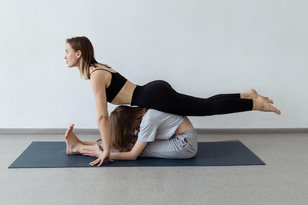 Sorelle yogi sportive che fanno yoga coppia di coppia di allenamento fitness