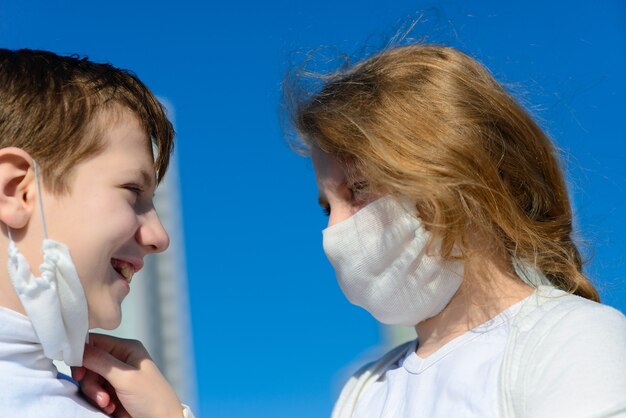 Sorellina e fratellino in abiti casual e maschere protettive pronti per la scuola