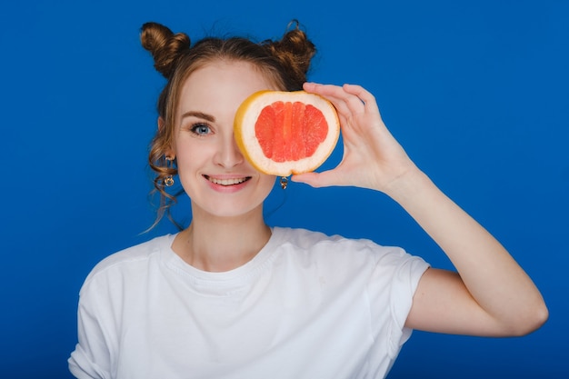 Sorpresa, la ragazza che ride tiene il pompelmo come le orecchie