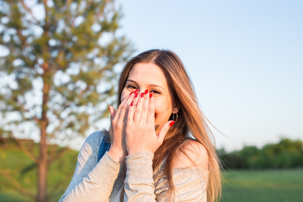 Sorpreso giovane donna con le mani sulla bocca all'aperto.