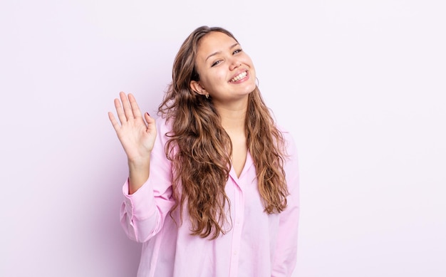 sorridendo allegramente e allegramente agitando la mano dandoti il benvenuto e salutandoti o salutandoti