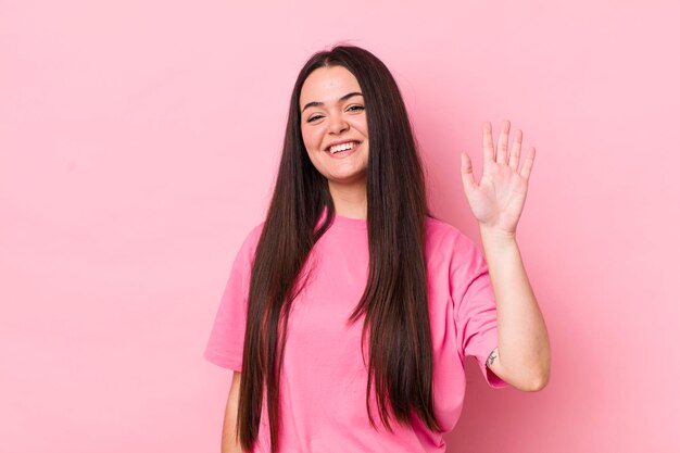 sorridendo allegramente e allegramente agitando la mano dandoti il benvenuto e salutandoti o salutandoti