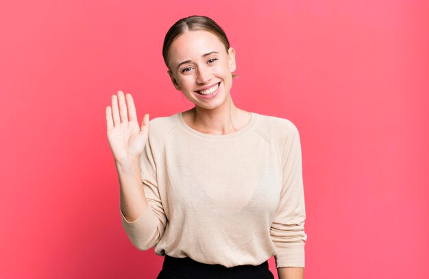 sorridendo allegramente e allegramente agitando la mano dandoti il benvenuto e salutandoti o salutandoti