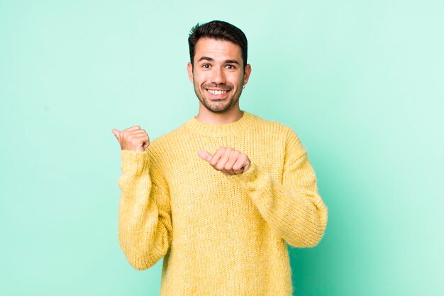 Sorridendo allegramente e con disinvoltura indicando di copiare lo spazio sul lato sentendosi felice e soddisfatto