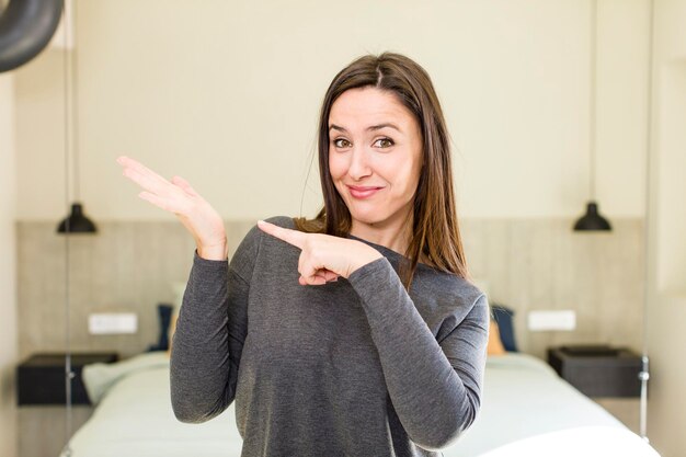 Sorridendo allegramente e indicando di copiare lo spazio sul palmo sul lato che mostra o pubblicizza un oggetto