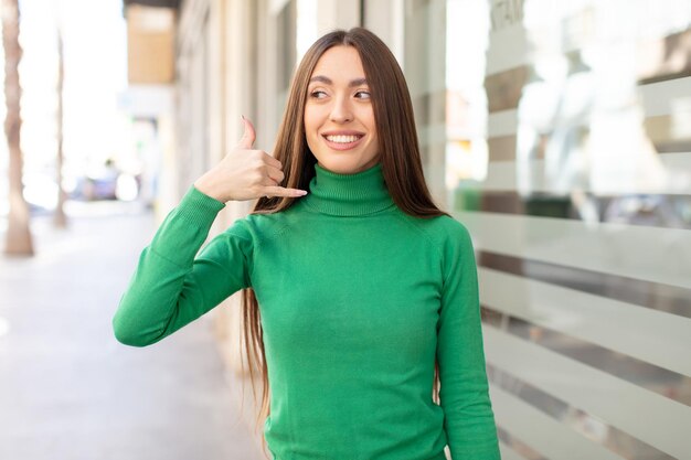 Sorridendo allegramente e indicando la fotocamera mentre si effettua una chiamata, in seguito gestisci parlando al telefono