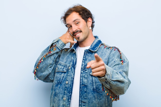 sorridendo allegramente e indicando la fotocamera mentre ti fai una telefonata in seguito gesto, parlando al telefono