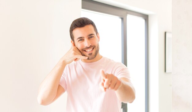 sorridendo allegramente e indicando mentre si effettua una chiamata in seguito gesto, parlando al telefono