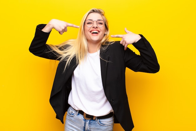 sorridendo con fiducia indicando il proprio ampio sorriso, atteggiamento positivo, rilassato, soddisfatto