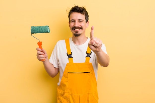 Sorridendo con orgoglio e sicurezza facendo il concetto di casa di pittura numero uno