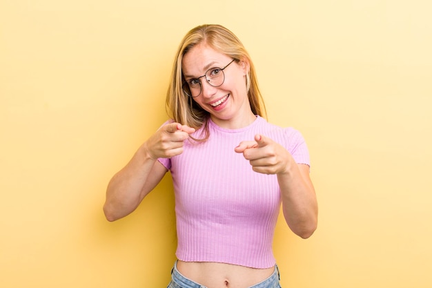 Sorridendo con un atteggiamento felice positivo positivo che punta alla telecamera facendo segno di pistola con le mani